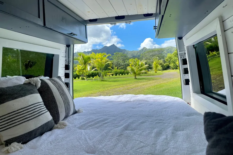 Campervan outside Back door of campervan open towards the tropical foliage