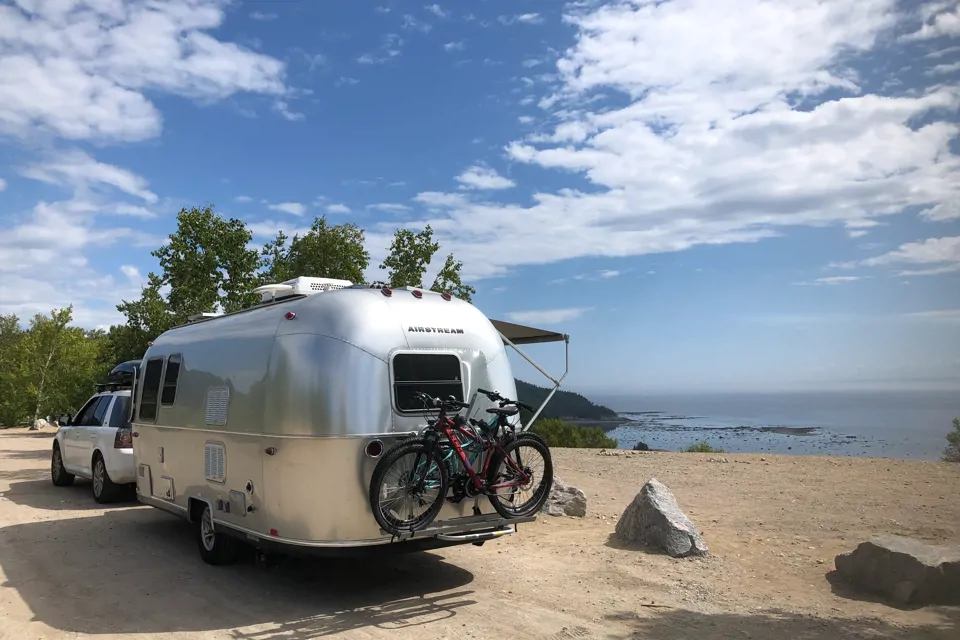 Truck pulling an Airstream next to the beach